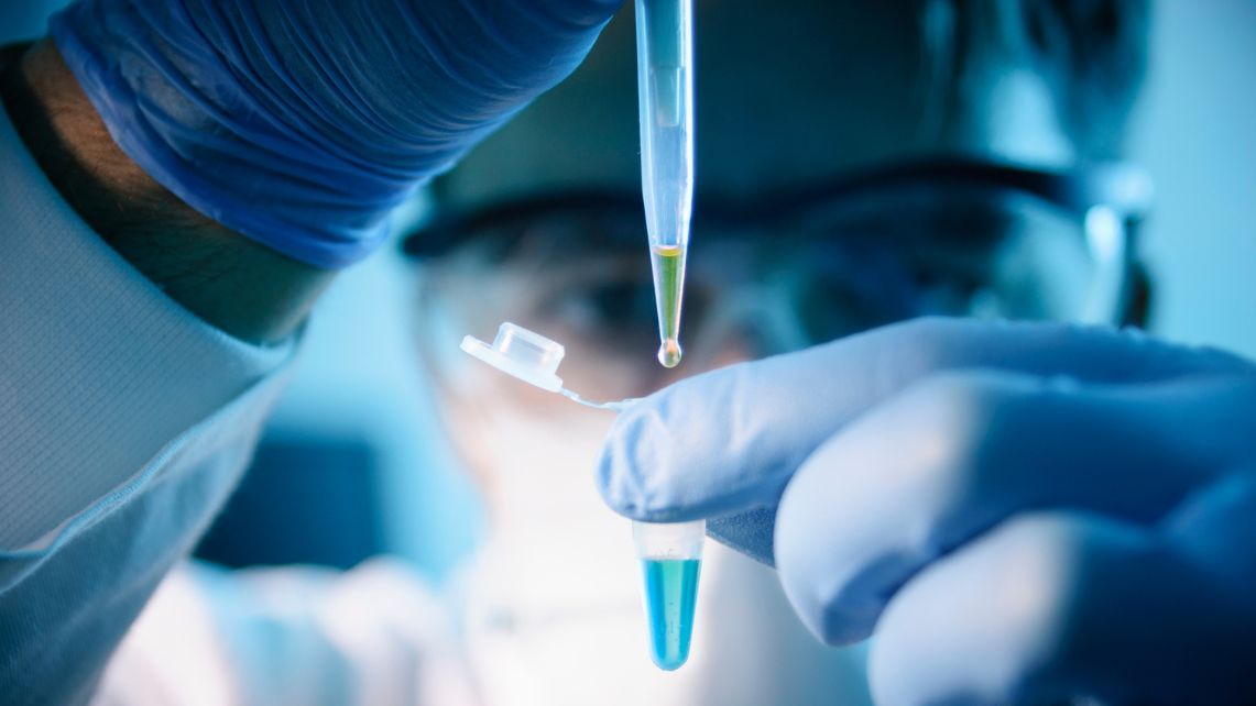 Gloved hands using a pipette to transfer liquid into a small lab tube, representing biomedical research advancements supported at UTMB