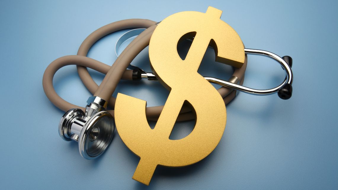 A gold dollar symbol on top of a stethoscope with a blue background